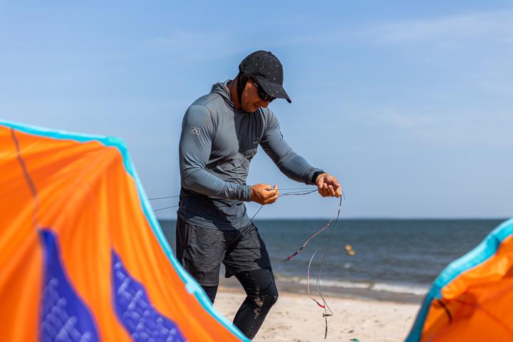 Montando a pipa laranja na areia