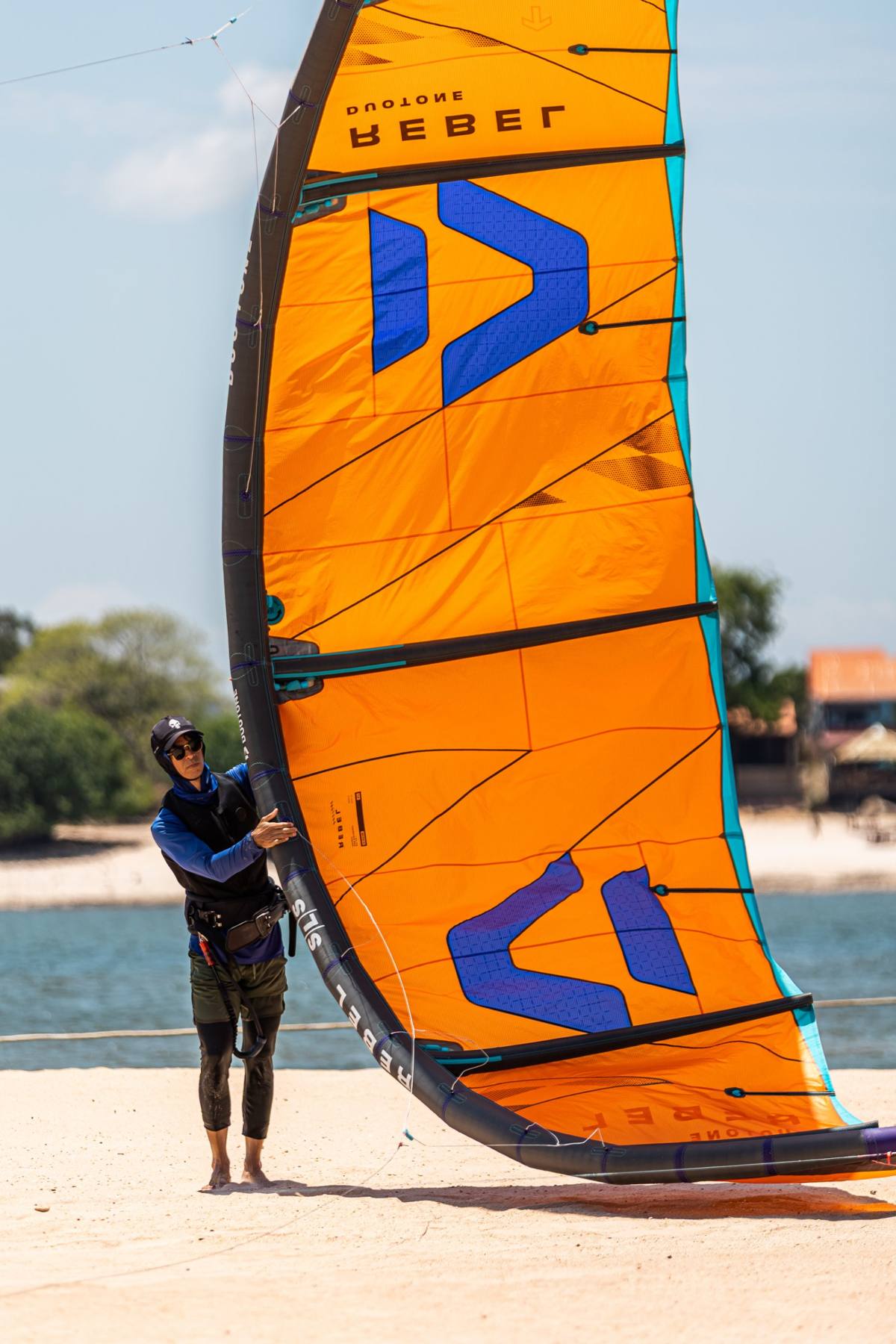 Kitesurfista com a pipa laranja na praia do Tapajós